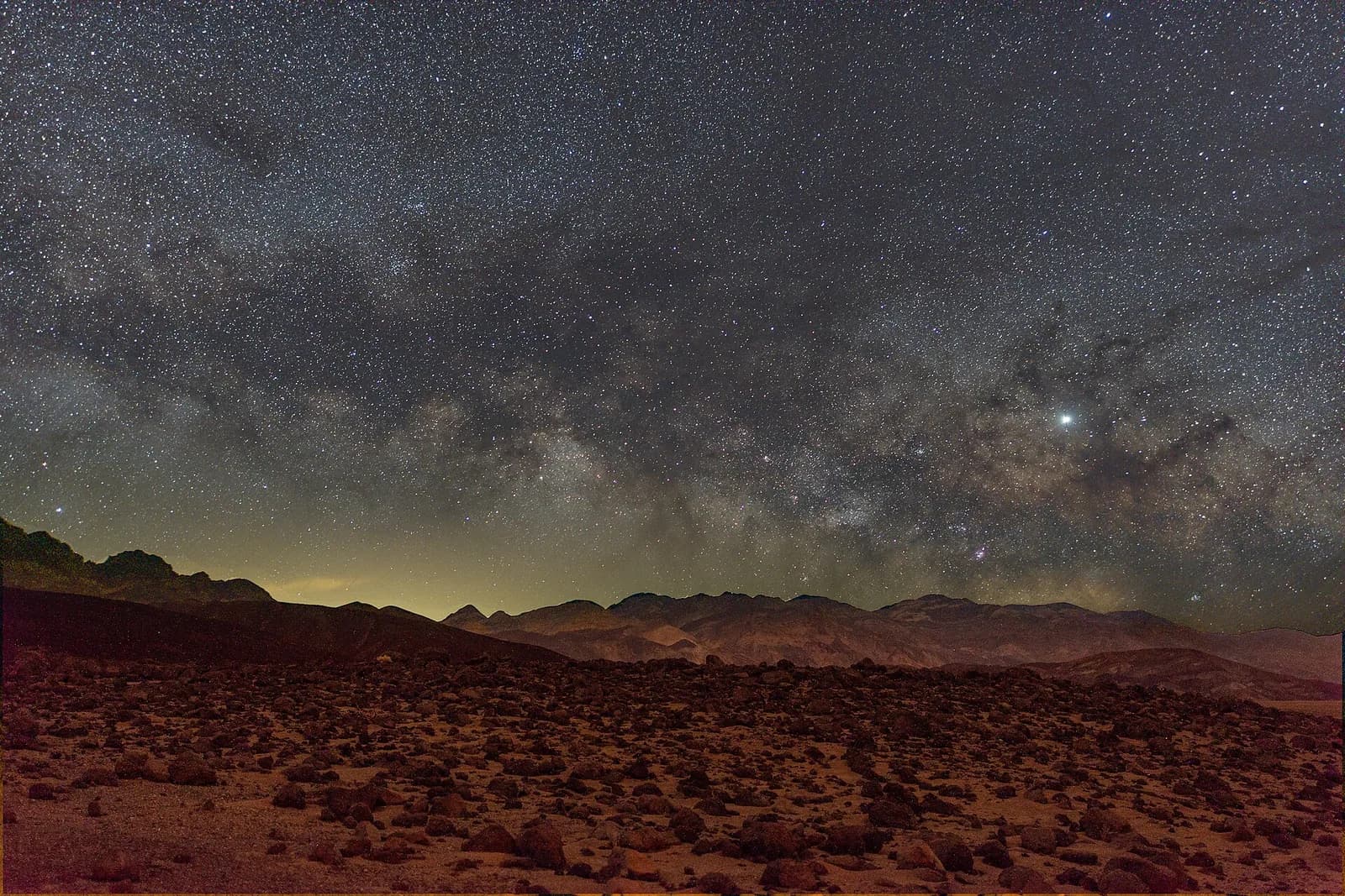 Star-filled night sky above a rocky plain in Death Valley National Park